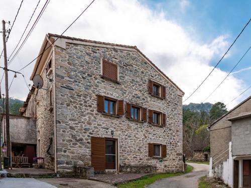 an old stone house with windows on a street at Apartment Migone de Sampolo - GHI306 by Interhome in Ghisoni