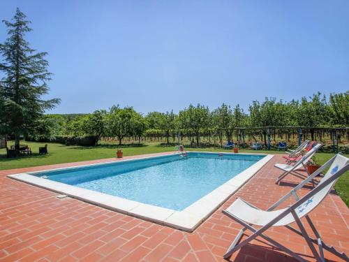a swimming pool with two lawn chairs next to it at Apartment Fattoria Petraglia - Padronale by Interhome in Monteriggioni