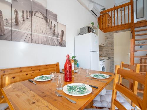 - une salle à manger avec une table en bois et une bouteille de vin dans l'établissement Holiday Home Lou Cantalou by Interhome, à Sainte-Marie-la-Mer