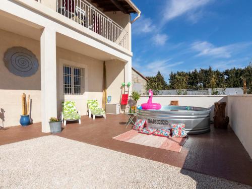 une terrasse avec un bain à remous et des chaises dans une maison dans l'établissement Holiday Home Mas de la Gourmette by Interhome, à Châteaurenard