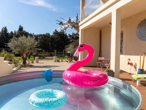 un flotteur de cygne rose dans une piscine dans l'établissement Holiday Home Mas de la Gourmette by Interhome, à Châteaurenard