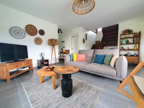 a living room with a couch and a table at Villa Ohana in Sainte-Anne