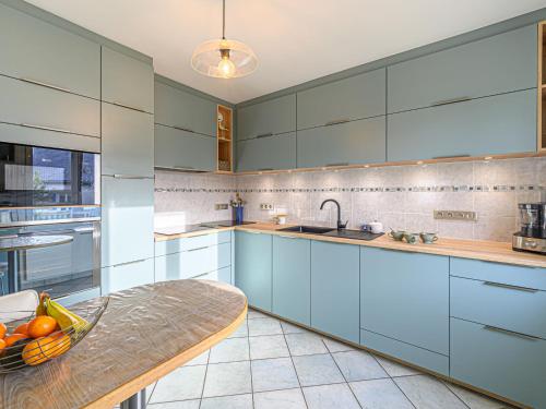 - une cuisine avec des armoires bleues et un bol de fruits sur une table dans l'établissement Holiday Home Phil'blue by Interhome, à Saint-Philibert