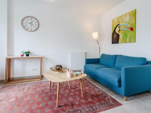 un salon avec un canapé bleu et une table dans l'établissement Apartment Les Arts-1 by Interhome, à Deauville
