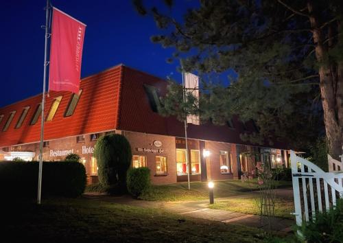 ein Gebäude mit einer roten Flagge in der Nacht in der Unterkunft Alt Lohbrügger Hof in Hamburg