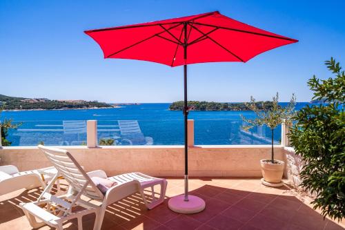 a red umbrella sitting on top of a patio at Apartments Lovro in Dubrovnik
