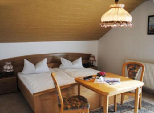 a bedroom with a bed and a table and a table and chairs at Gasthof-Hotel-Löwen in Hechingen