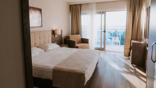 um quarto de hotel com uma cama grande e uma janela em Faustina Hotel & Spa em Güzelçamli