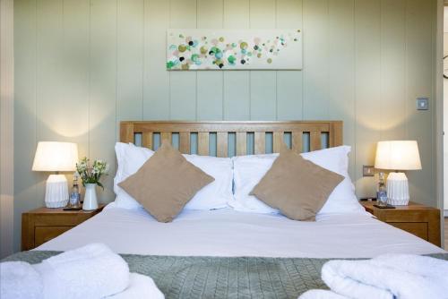 a bedroom with a bed with white sheets and pillows at Whileaway Lodge, Strawberryfield Park in Cheddar