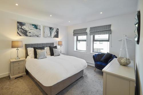 a bedroom with a white bed and a blue chair at Host & Stay - Beach Pad in Whitby