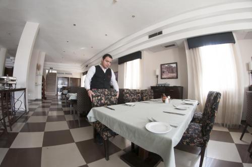 a man sitting at a table in a dining room at La Maison Hotel in Wadi Musa