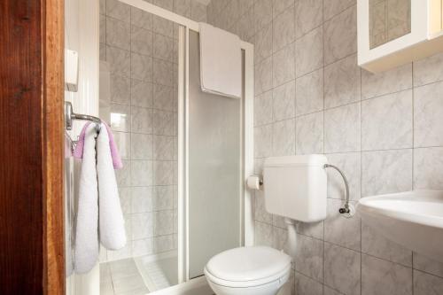 a white bathroom with a toilet and a sink at Apartments Jadranka in Medulin
