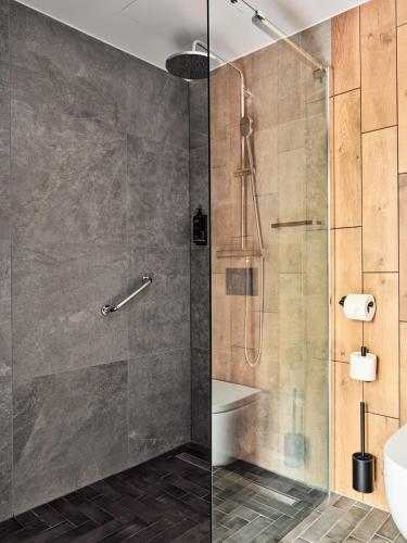 a bathroom with a shower with a glass door at Hotel Bergo Resort & SPA in Szklarska Poręba