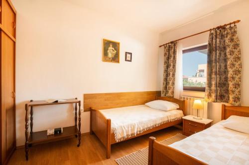 a bedroom with two beds and a tv and a window at Apartments Jadranka in Medulin