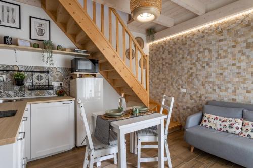 Il comprend une cuisine et un salon avec une petite table et des chaises. dans l'établissement Loft 35 - private parking, à Quartu SantʼElena
