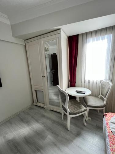 a room with a table and chairs and a window at Nacre Residence in Istanbul