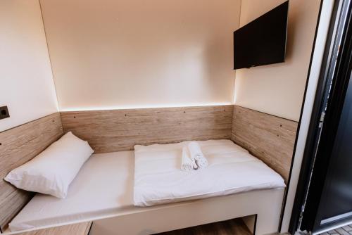 małe łóżko w narożniku małego pokoju w obiekcie Roatel Schipkau (A13) my-roatel-com w mieście Schipkau