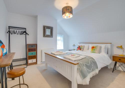 a bedroom with a white bed and a table and chairs at Uwch Ogwen in Bethesda