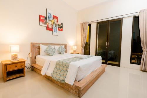 a bedroom with a bed and a large window at Arunika Cottage in Nusa Penida
