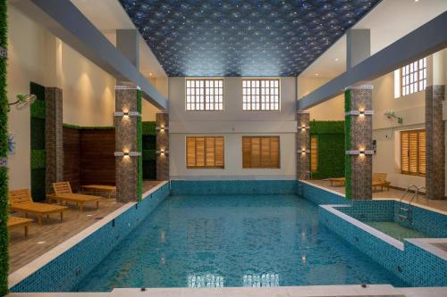 a pool in a building with a swimming pool at Golden Retreat in Baharampur