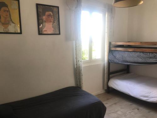 une chambre avec deux lits superposés et une fenêtre dans l'établissement Maison vue mer à GUETHARY 7 personnes, à Bidart