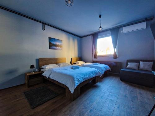 a bedroom with a large bed and a couch at XXL Rooms Osijek in Osijek