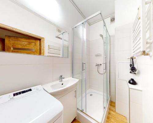 a white bathroom with a sink and a shower at roomspoznan pl - Ogrodowa 9 - 24h self check-in in Poznań