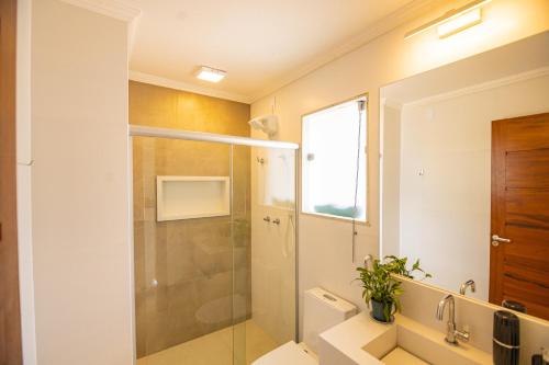 uma casa de banho com um chuveiro, um WC e um lavatório. em APART LAGOA BUZIOS- centro em Búzios
