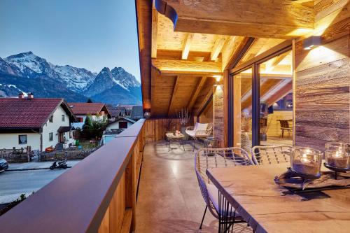 einen Balkon mit einem Tisch, Stühlen und Bergen in der Unterkunft Chalet Alpi in Garmisch-Partenkirchen