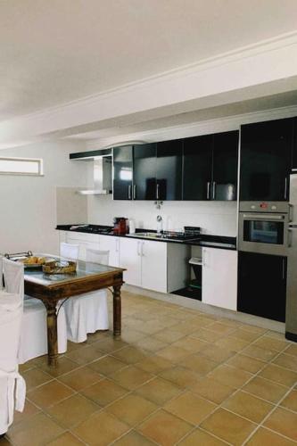 a kitchen with black and white cabinets and a table at Casa da Oliveira in Nelas