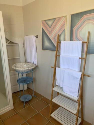 a bathroom with a towel rack and a table with towels at Casa da Oliveira in Nelas