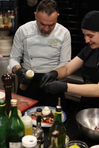 a man and a woman preparing food in a kitchen at Dim's Hotel & Restaurant in Korçë