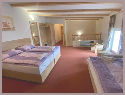 オストラヴァにあるApartmány Tivaの広いベッドルーム(ベッド2台、テーブル付)