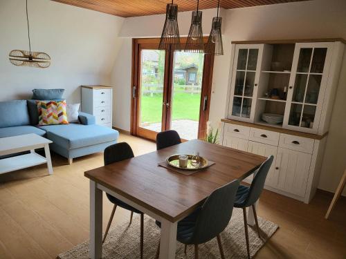 eine Küche und ein Wohnzimmer mit einem Holztisch und Stühlen in der Unterkunft Ferienhaus Yanic in Neuharlingersiel