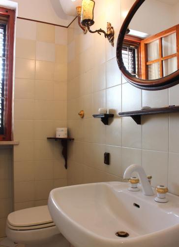 a bathroom with a sink and a toilet and a mirror at "Lilla" in Calci
