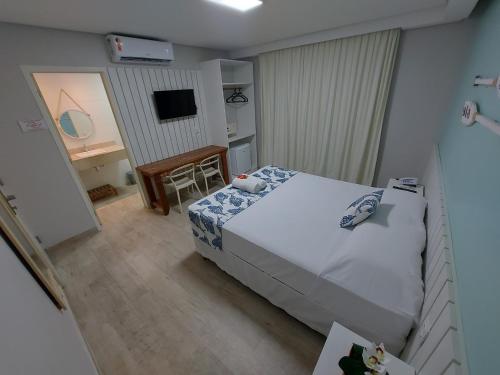 Dormitorio con cama, escritorio y TV en Pousada Ecos Beach en Porto De Galinhas