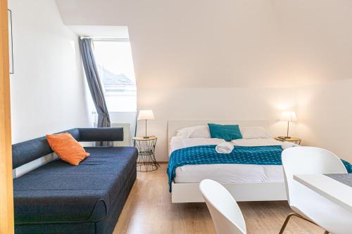 een slaapkamer met een bed en een bank bij Vibrant Aparment perfect for Long Stays in Wenen
