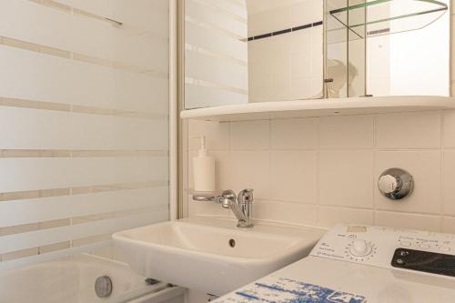 a white bathroom with a sink and a tub at Vibrant Aparment perfect for Long Stays in Vienna
