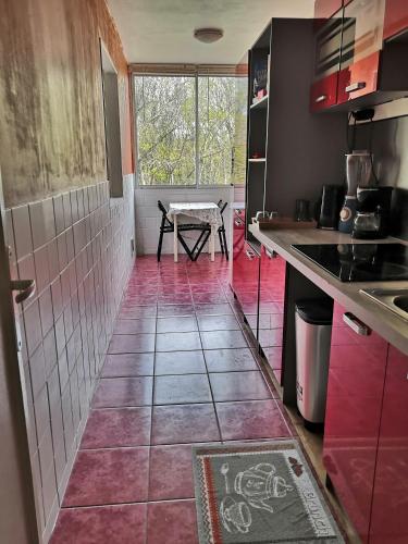 a kitchen with a tile floor and a table at Chambre d'hôte au PARC DES THIBAUDIERES in Boussy-Saint-Antoine