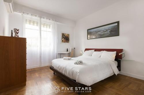 sypialnia z dużym łóżkiem z białymi prześcieradłami w obiekcie Suite Flora Five stars Holiday house w Nicei