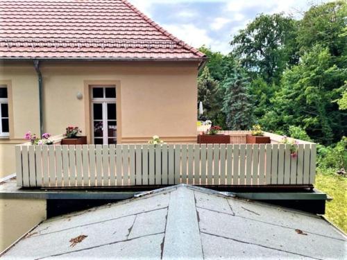 Oschatz的住宿－Moderne Gästewohnung "Am Weinberg"mit Terrasse，房屋顶部的白色围栏