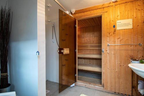 a wooden bathroom with a shower and a sink at Y Beudy, Converted Former Dairy in Conwy