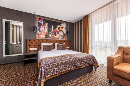 a hotel room with a bed and a chair at Resort Hotel Elija in Šventoji