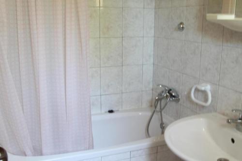 ein Badezimmer mit einer Badewanne, einem Waschbecken und einem Duschvorhang in der Unterkunft Apartment in Razanj with sea view, terrace, air conditioning, WiFi 5150-2 in Ražanj