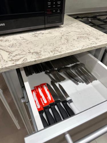 a drawer in a kitchen filled with utensils at منتجع اووه يامال البحري في الخيران OOh Yaa Mal in Al Khīrān