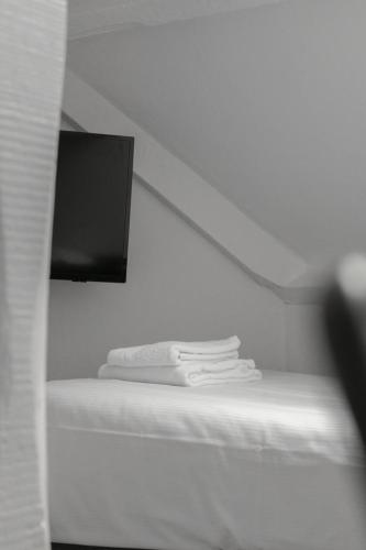 a pile of towels sitting on a shelf in a room at Hotel de la Bourse in Maastricht