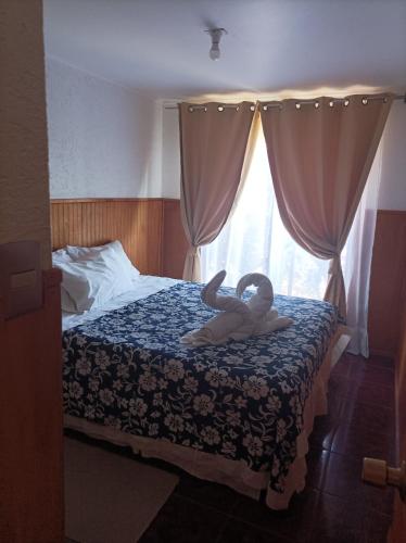 two towels on a bed in a bedroom with a window at Cabañas MANA NUI INN in Hanga Roa