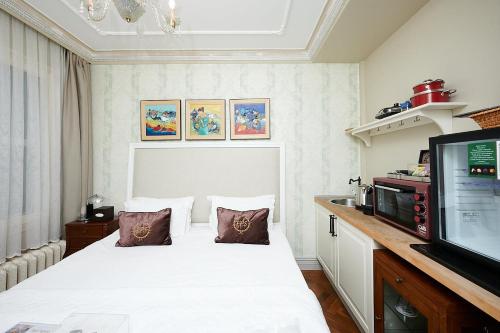 a bedroom with a white bed and a television at Faik Pasha Hotels Special Category Beyoglu Istanbul in Istanbul