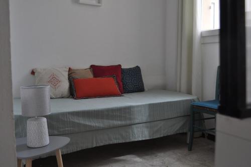 um sofá com almofadas na sala de estar em Appartement duplex plein sud sur le port de Bonifacio em Bonifacio