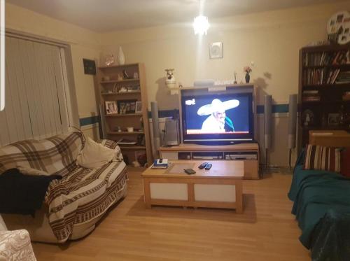 ein Wohnzimmer mit einem TV und einem Cowboy auf dem Bildschirm in der Unterkunft Double bedroom in Liverpool in Liverpool